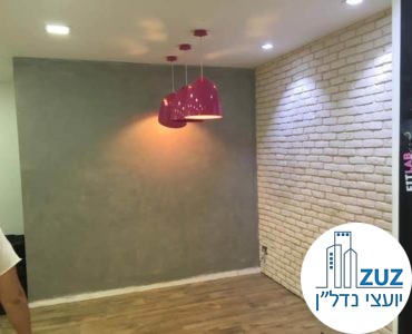 קיר מעוצב עם מנורות ורודות בסטודיו בבניין משרדים בשכונת מונטיפיורי תל אביב
